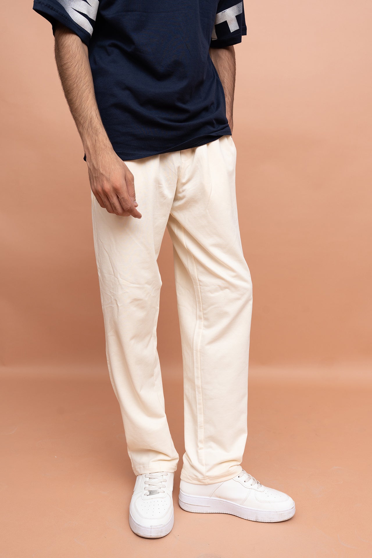 Model wearing VIVE Never Settle regular fit graphic T-shirt with cream loose fit cotton terry trousers for premium casual fashion.